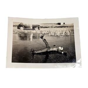 1940s B&W Photo Man Ice Skating Fell Frozen Lake Vehicle in Back Snapshot Funny